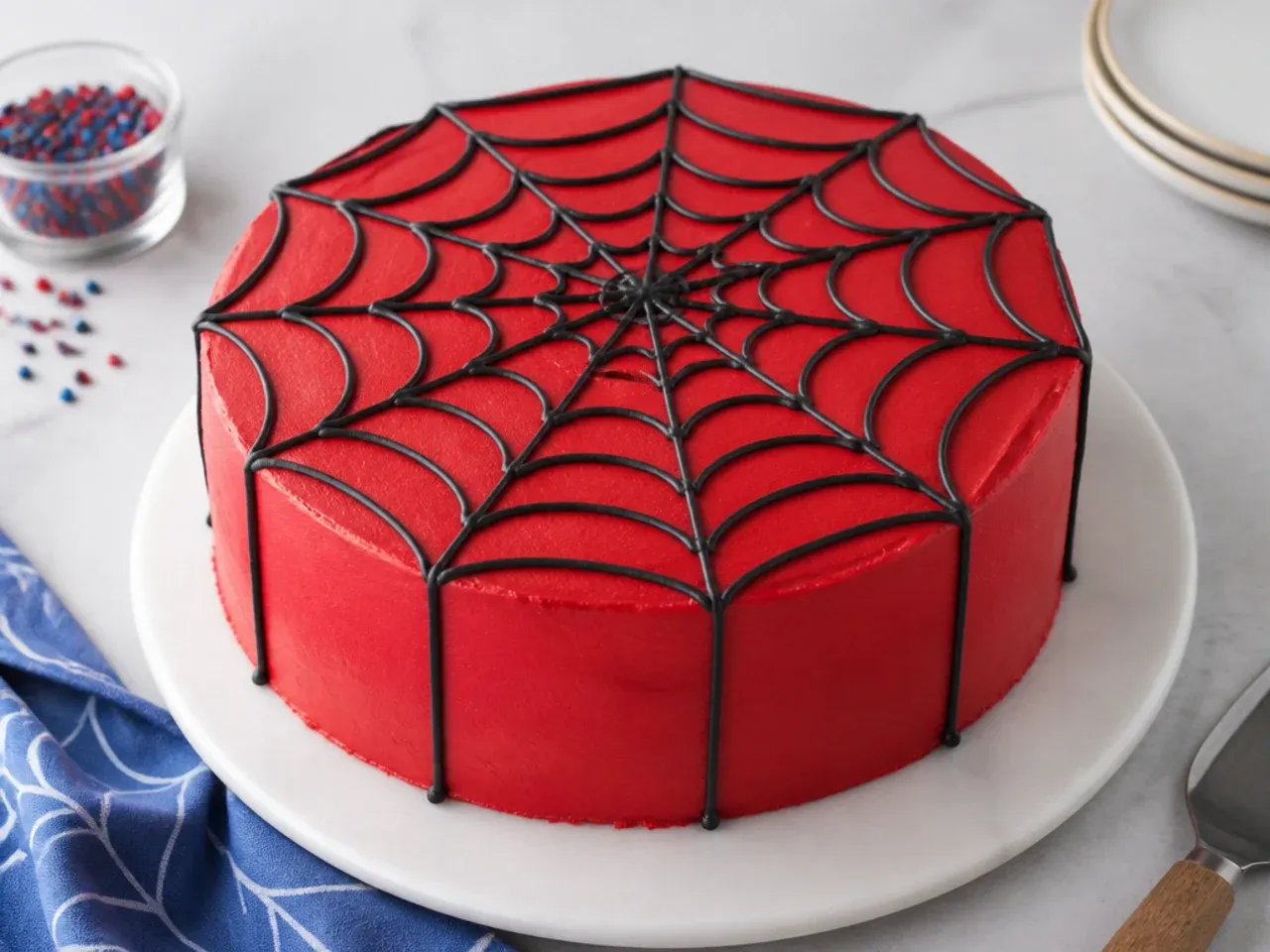 Simple Spiderman cake with smooth red buttercream and a black piped web on top