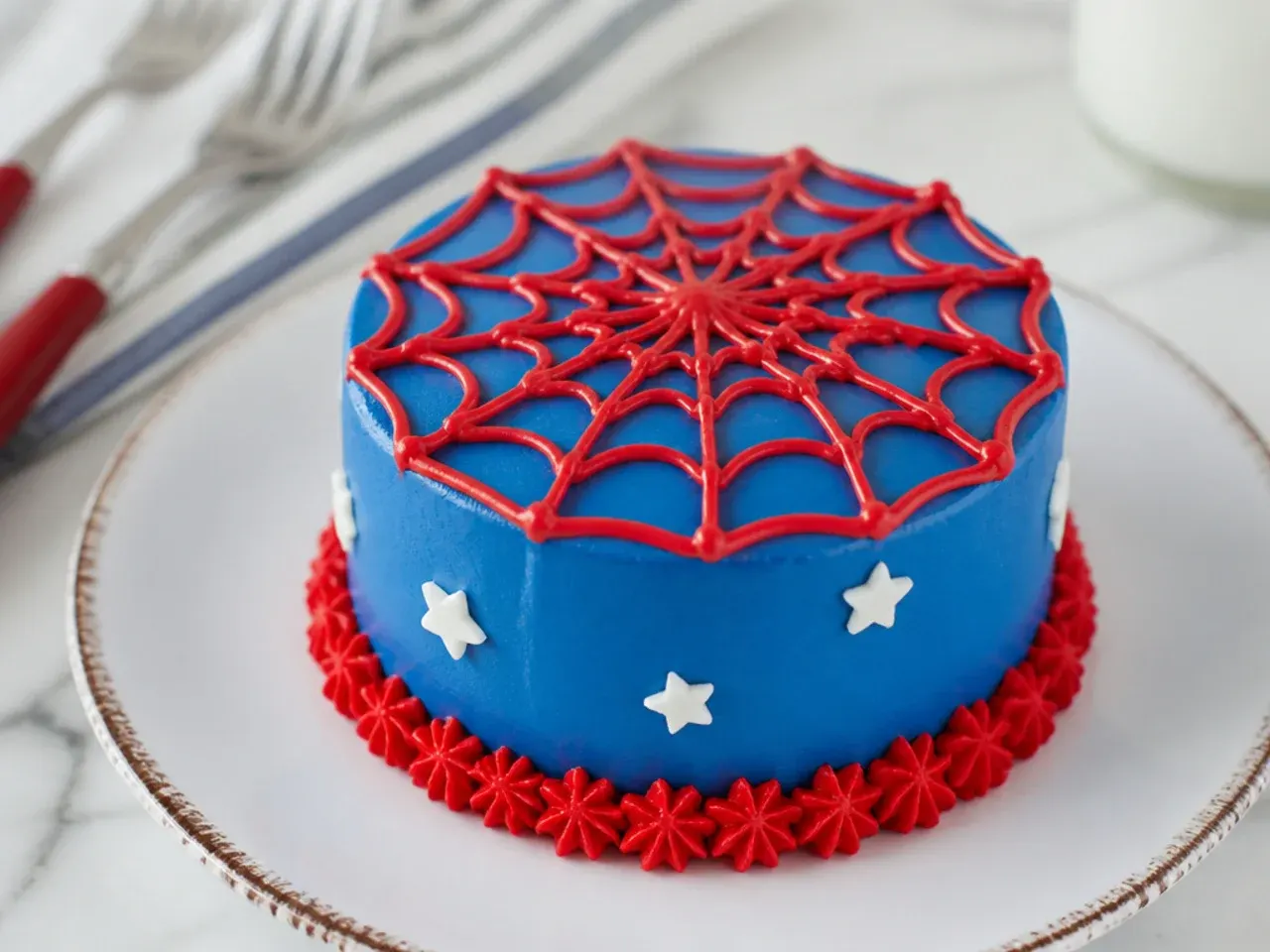 Charming mini personal Spiderman cakes each with a small red buttercream web