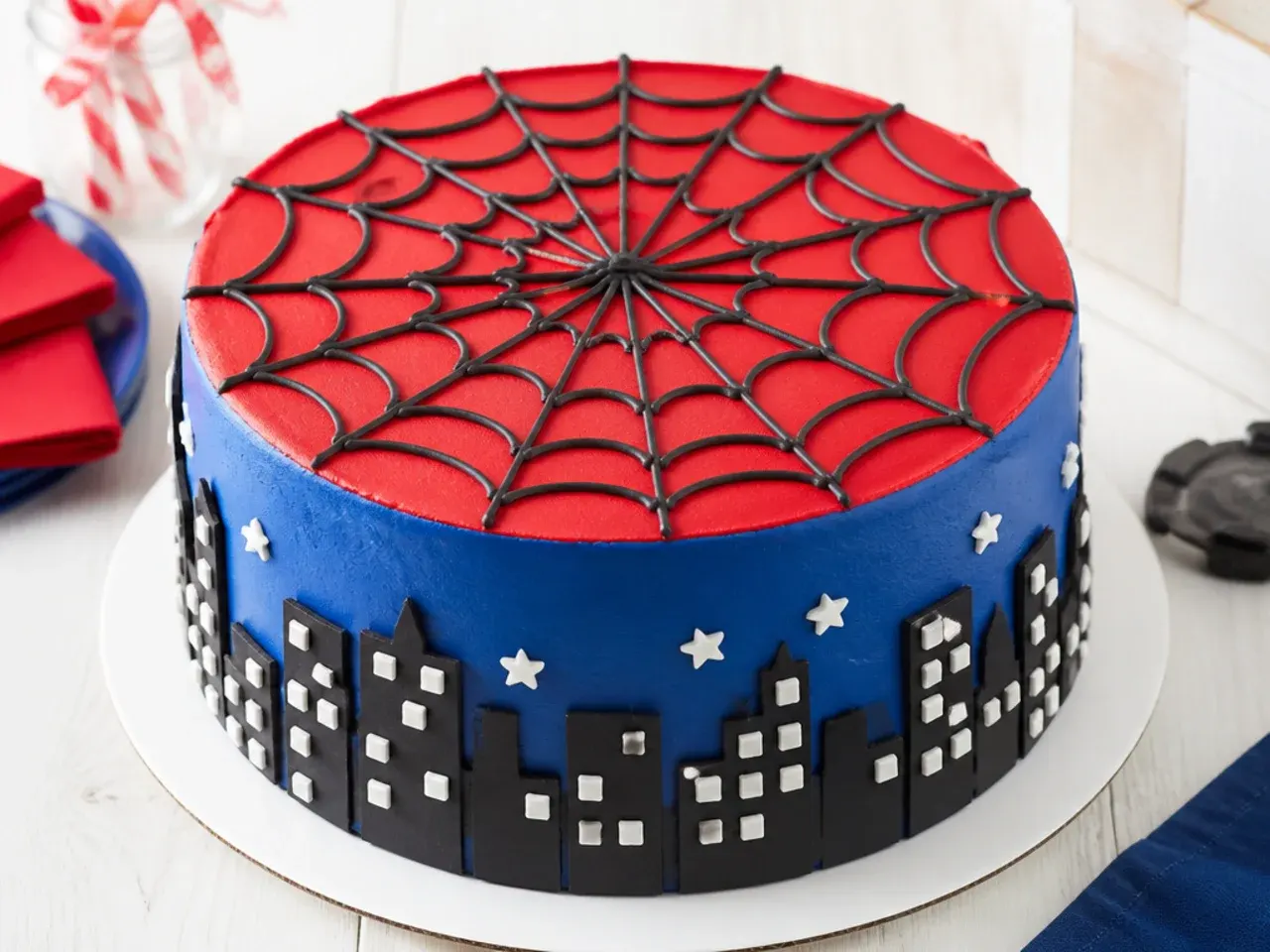 Classic red and blue Spiderman cake for boys with piped black buttercream web on top