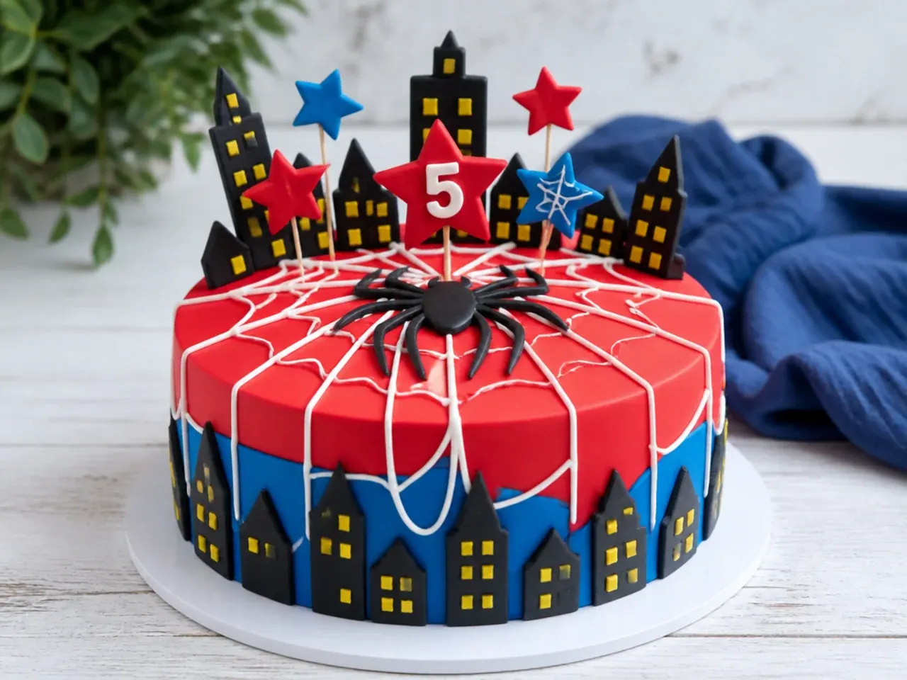 Whimsical Spiderman cake for boys with a fondant city skyline and web strands