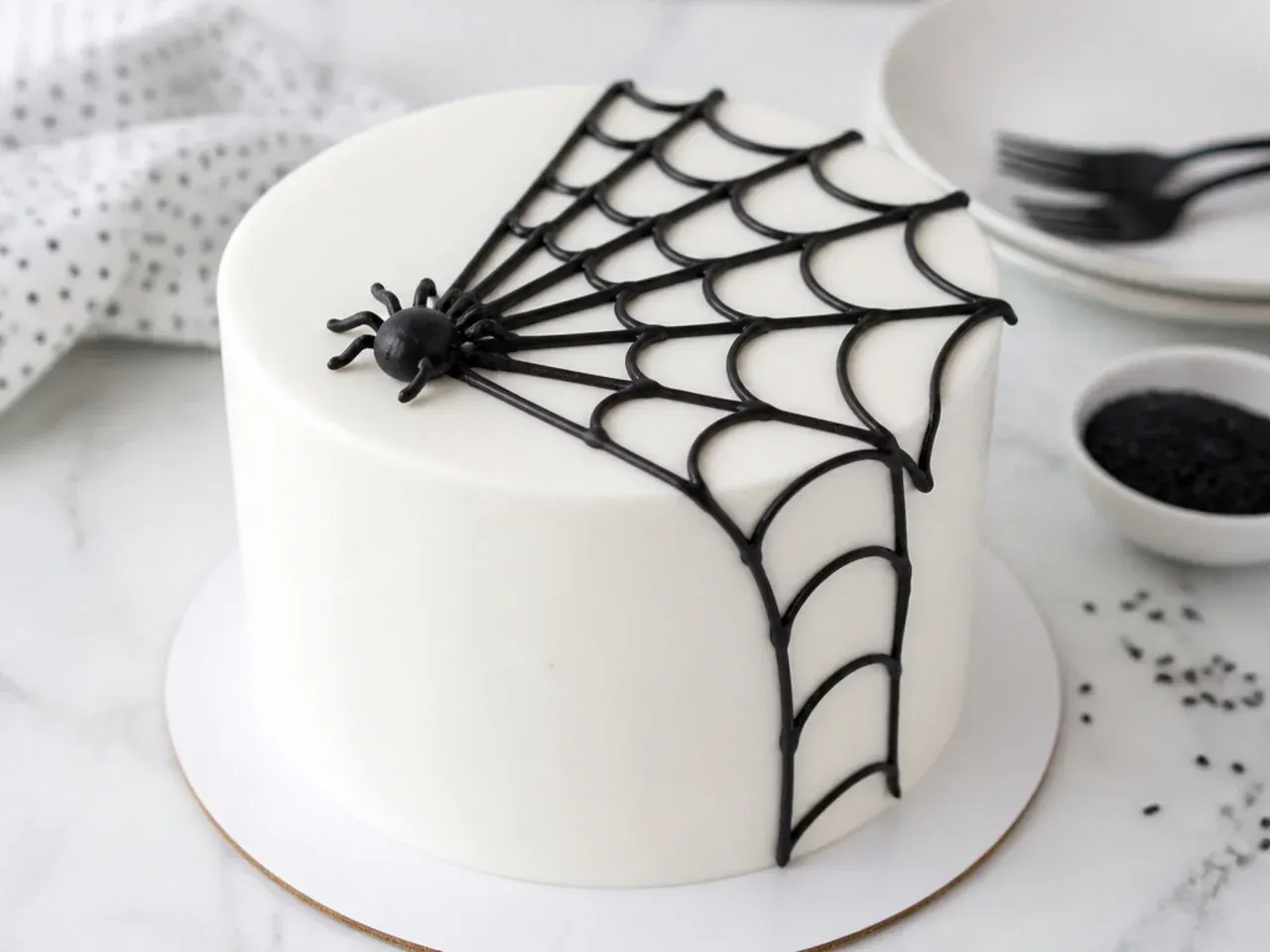 Minimal white spiderman cake idea with single black corner web and tiny fondant spider