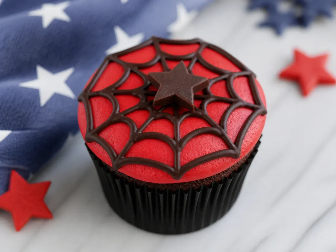 Easy Spiderman cupcake idea with chocolate web drizzle over red frosting
