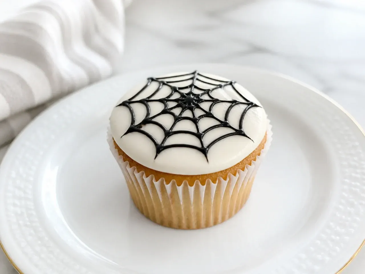 Minimal white Spiderman cupcake with a single black web design
