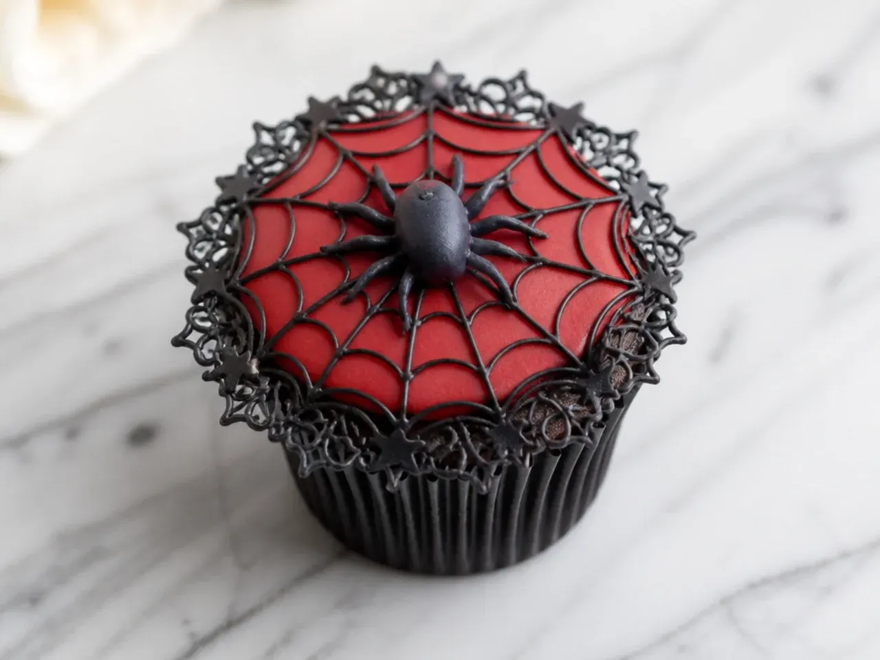 Delicate Spiderman cupcake with fine piped web lace border