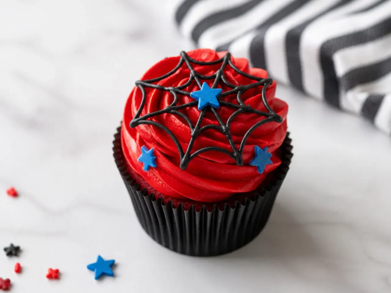 Charming mini Spiderman cupcakes with small red swirls and web detail