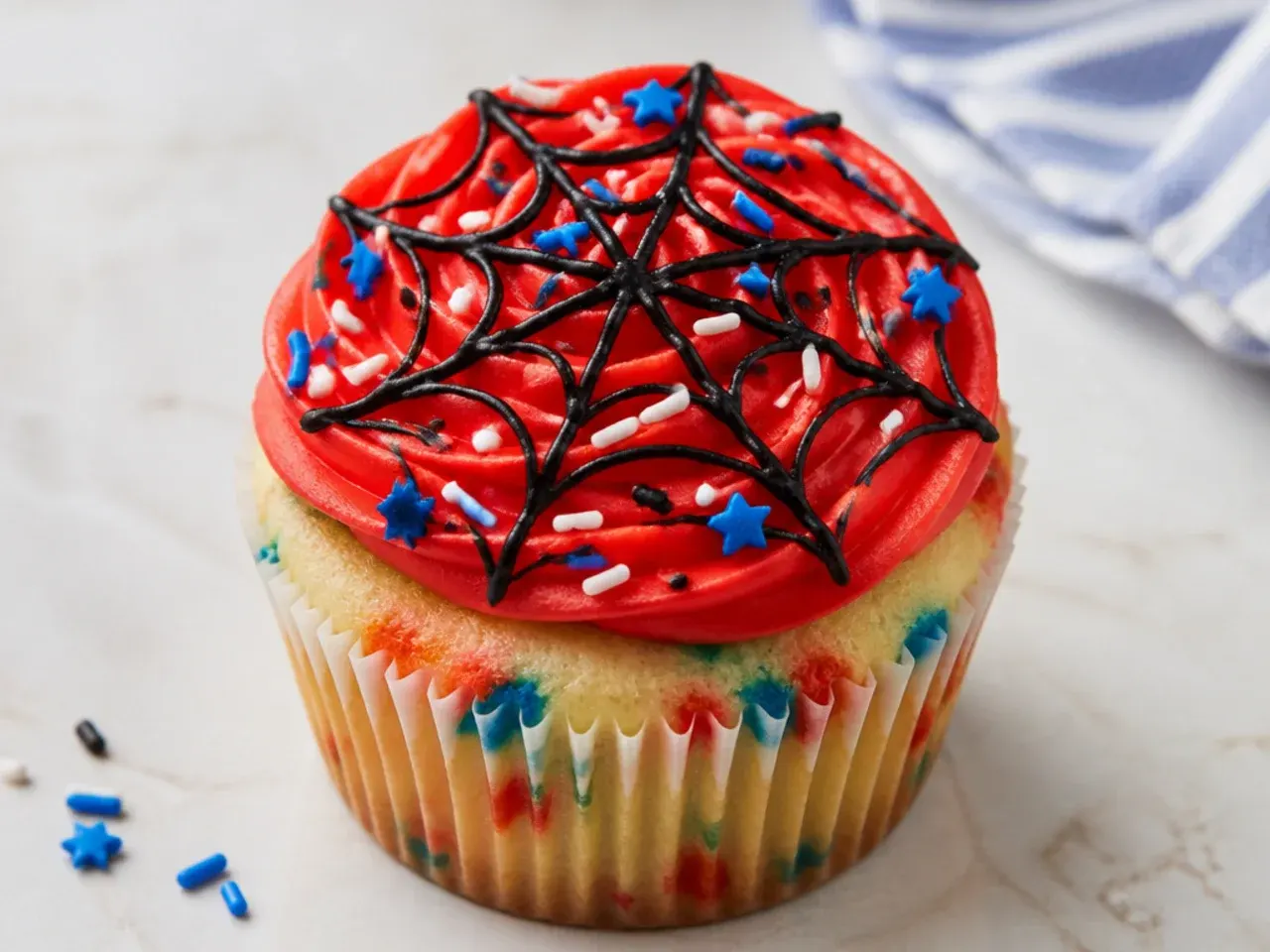 Colorful confetti Spiderman cupcakes with red web swirl and sprinkles