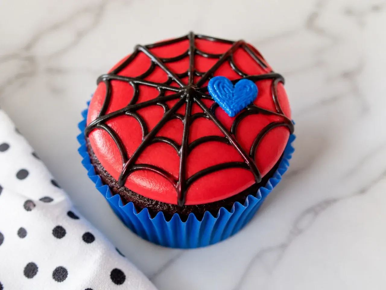 Charming Spiderman cupcakes with a web and small piped heart
