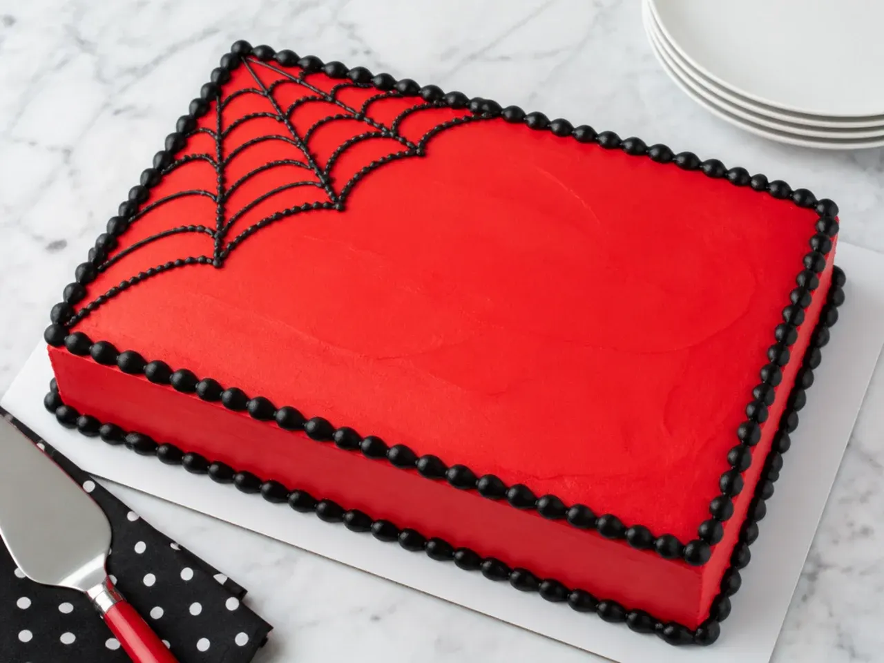 Minimal red Spiderman sheet cake with a single black web in one corner