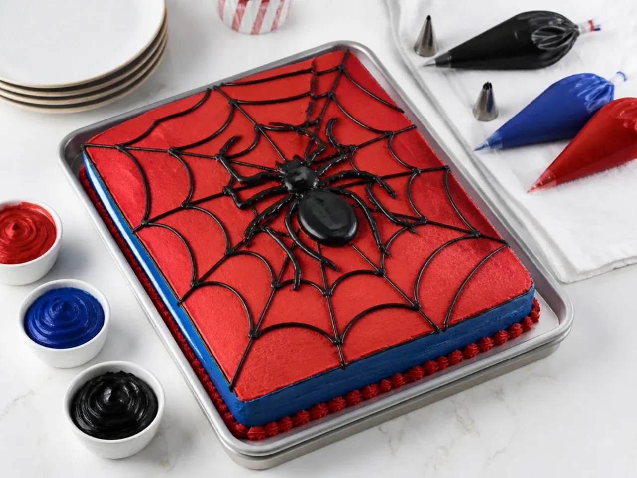 Decorating tips for an easy Spiderman sheet cake with gel colors and piping tips