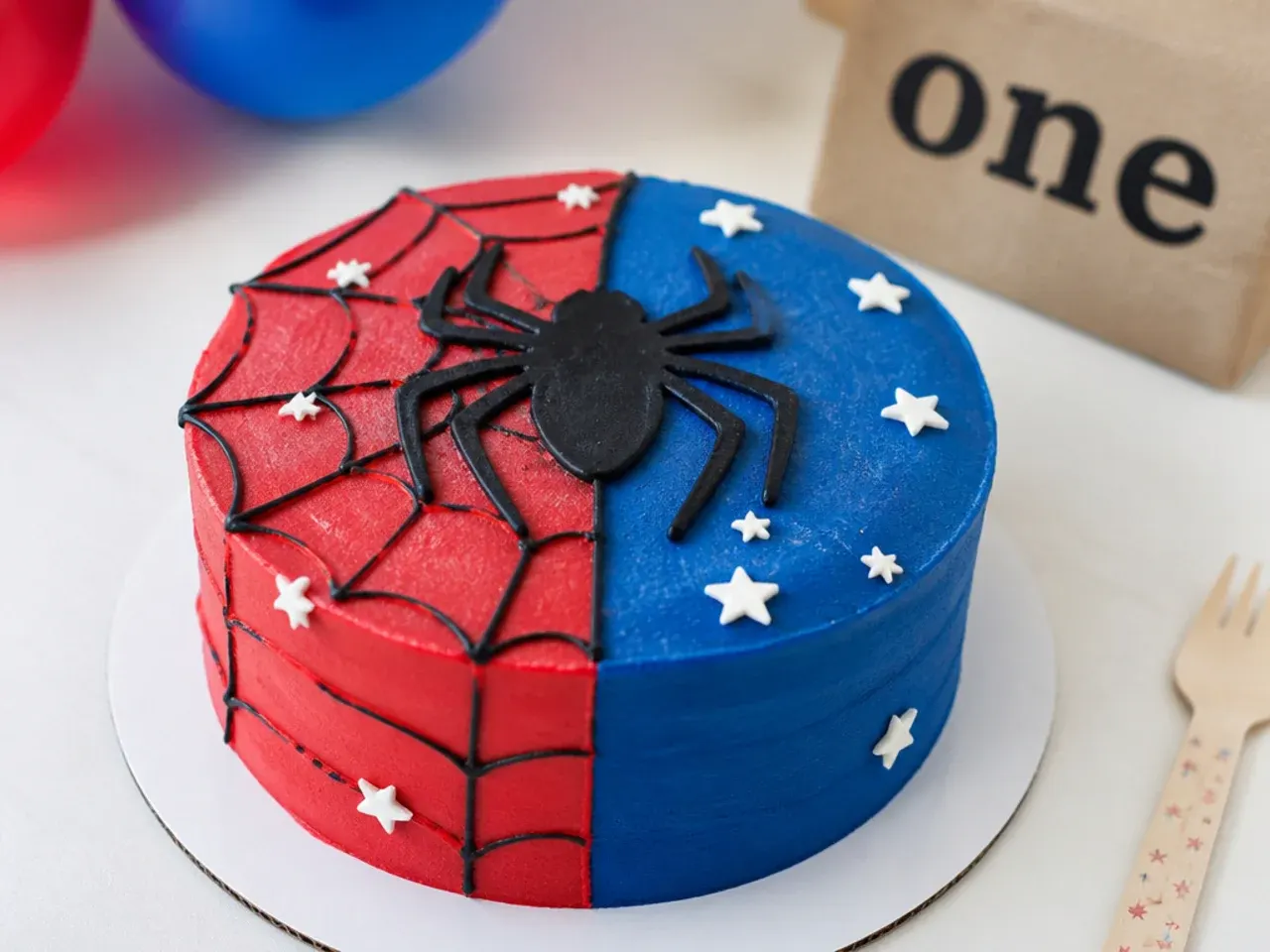 Modern colour-block spiderman smash cake with sharp red and blue halves