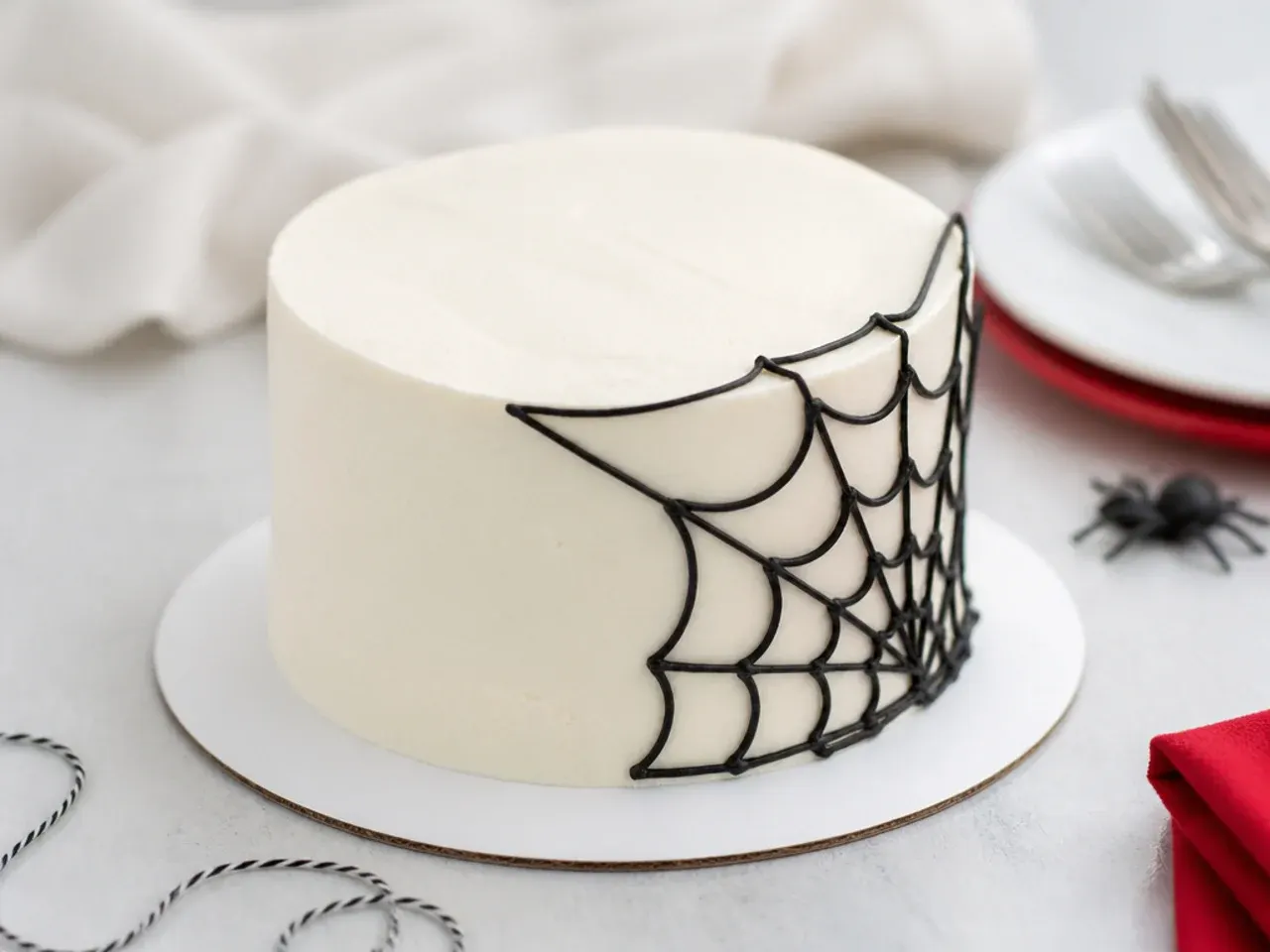 Minimal white smash cake with a single black corner web, simple spiderman smash cake design