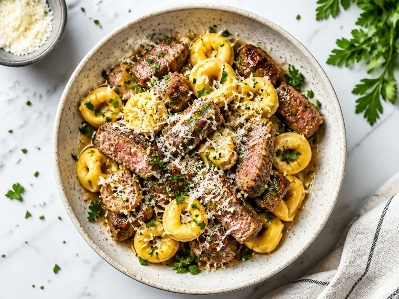 Steak and tortellini leftovers packed into a glass airtight container ready for the fridge