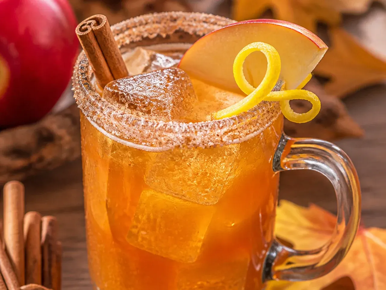 Heatproof mug of spiced rum apple cider with steam rising and a cinnamon stick garnish