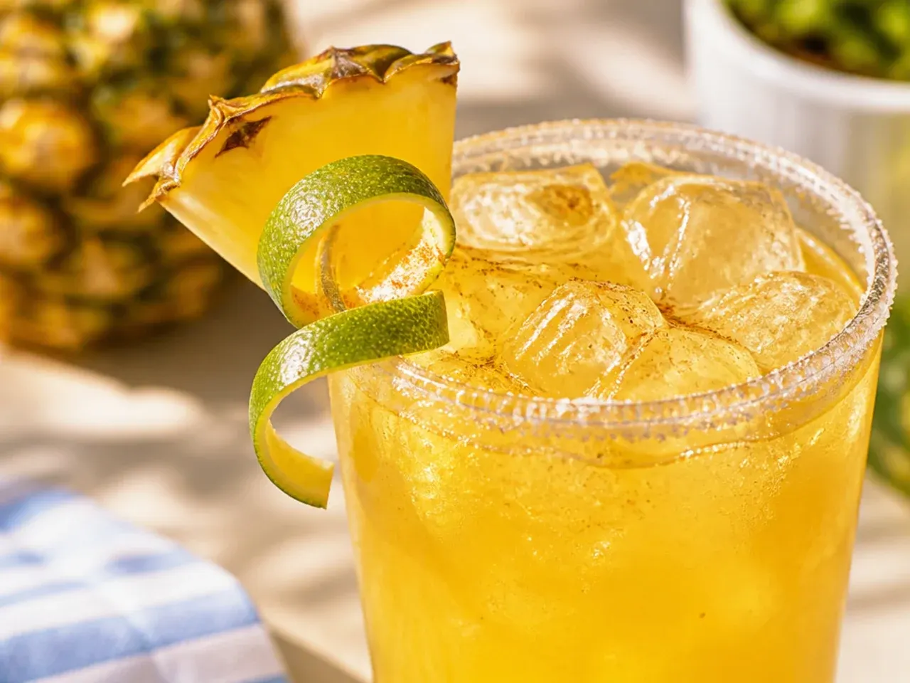 Spiced ginger-pineapple cooler in a copper mug with a candied ginger garnish