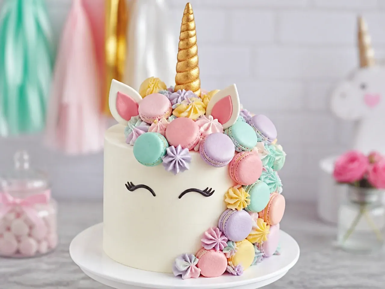 Playful unicorn cake with a mane made of mini pastel macarons and rosettes