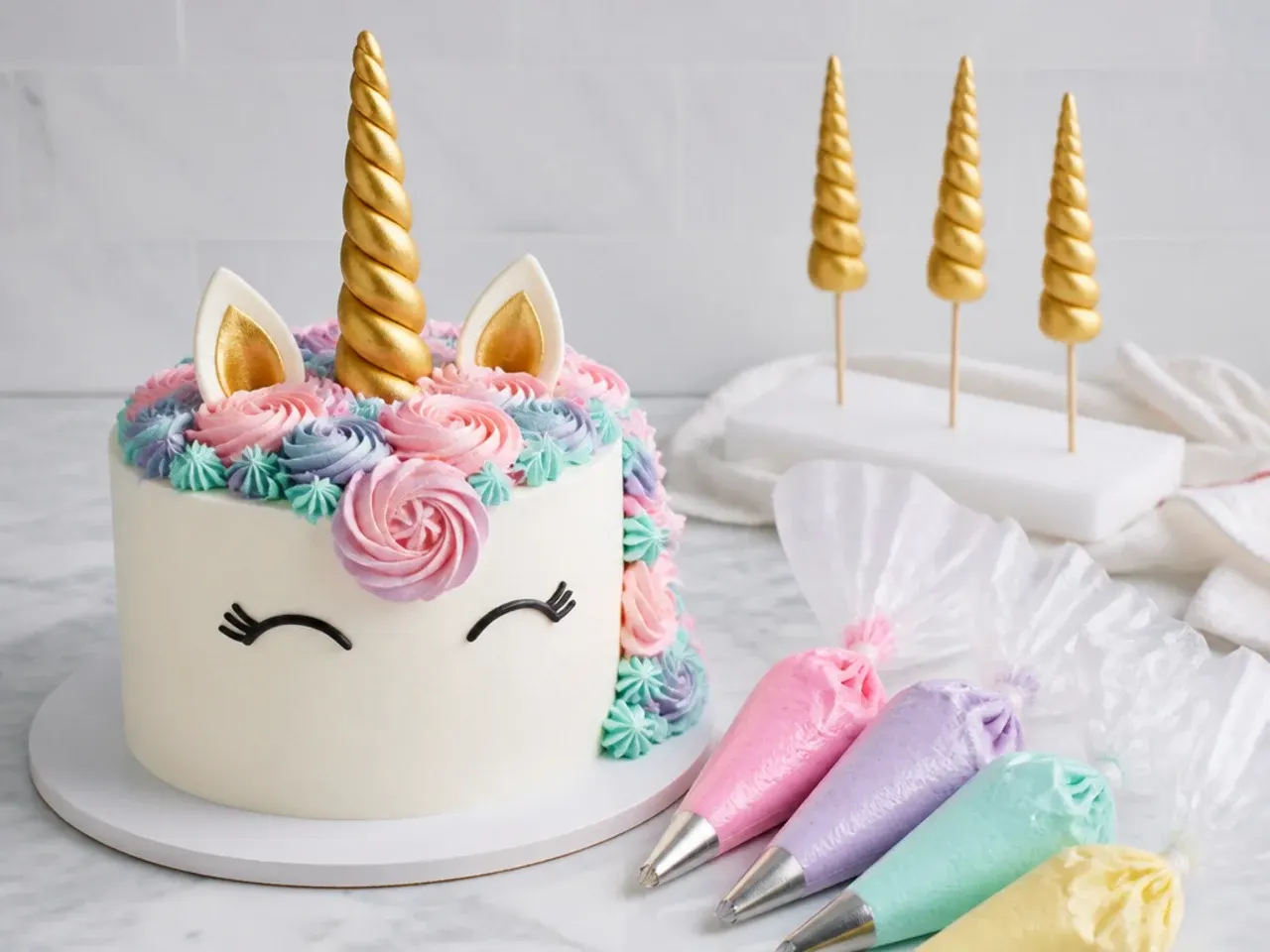 Tips for making a unicorn birthday cake easier with piping bags and fondant horn drying