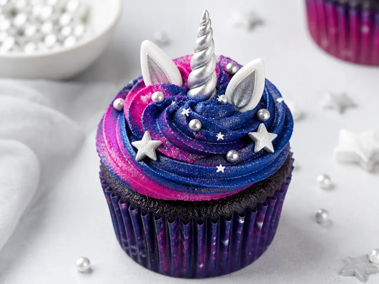 Bold galaxy unicorn cupcakes in navy and magenta with edible silver stars